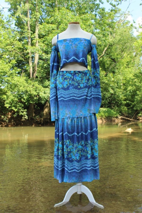 Blue two-piece garment on a dress form by the water